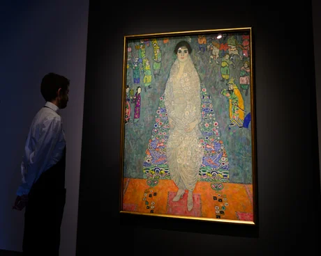 Sotheby's Küresel Genel Merkezi Büyük Açılışı NEW YORK, NEW YORK - 7 KASIM: Gustav Klimt'in Bildnis Elisabeth Lederer (Elisabeth Lederer Portresi) adlı eserinin önünde duran bir sanat danışmanı, 7 Kasım 2025'te New York'taki Sotheby's'de düzenlenen basın ön gösterimi sırasında bir kadın tarafından filme alındı. Tablonun 150 milyon doların üzerinde bir fiyata satılacağı tahmin ediliyor. Sotheby's, yarın Madison Avenue'deki Marcel Breuer binasında yeni küresel genel merkezini açıyor. Alan, müzayede ön gösterimleri sona erene kadar halka açık ve ücretsiz olacak. Yaklaşan satışlar arasında Leonard A. Lauder Koleksiyonu, Cindy ve Jay Pritzker Koleksiyonu, Şimdi ve Çağdaş Müzayede, Exquisite Corpus Müzayedesi ve 18-21 Kasım 2025 tarihleri ​​arasında yapılması planlanan Modern Gün Müzayedesi yer alıyor. (Fotoğraf: Alexi Rosenfeld/Getty Images)