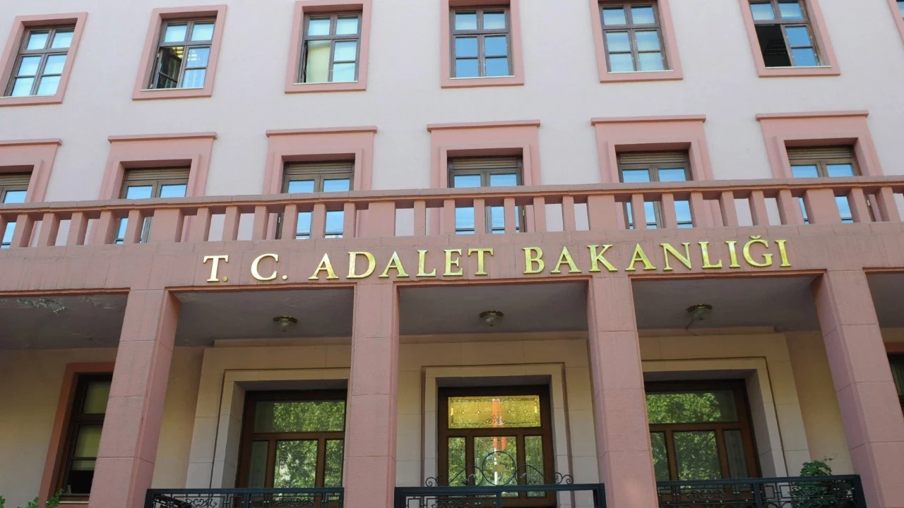 Facade of Turkey's Ministry of Justice building with pink pillars and gold lettering reading 'T. C. Adalet Bakanlığı' above the entrance.