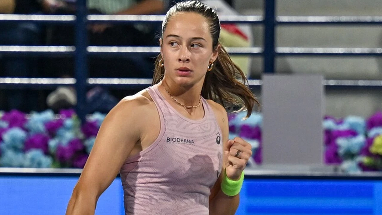 Female tennis player in a pink sleeveless top on a court, looking off to her left during a match.