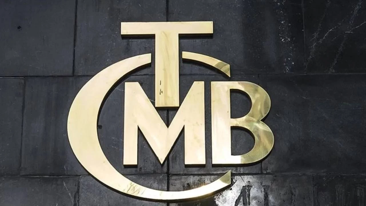 Gold monogram logo on a dark wall showing a curved 'C' encircling 'M' and 'B' with a 'T' atop the letters.